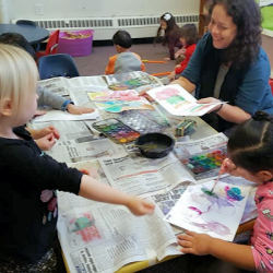 preschool teacher helping students learn through art projects